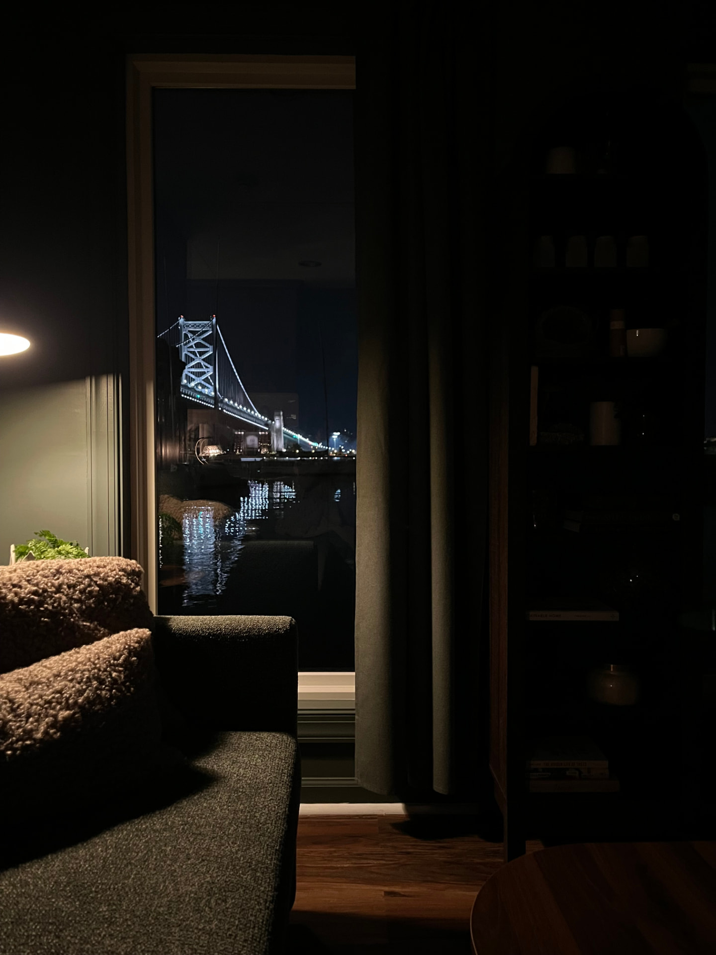 Night view of the lit Ben Franklin Bridge through the living room window