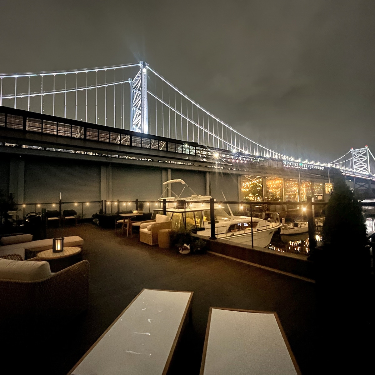 Rooftop lounge at night beneath the bridge